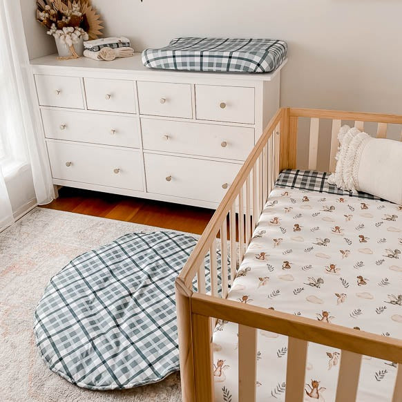 Modern nursery set up with a change mat cover, fitted cot sheet and a cotton playmat all in the blue cyprus plaid print 