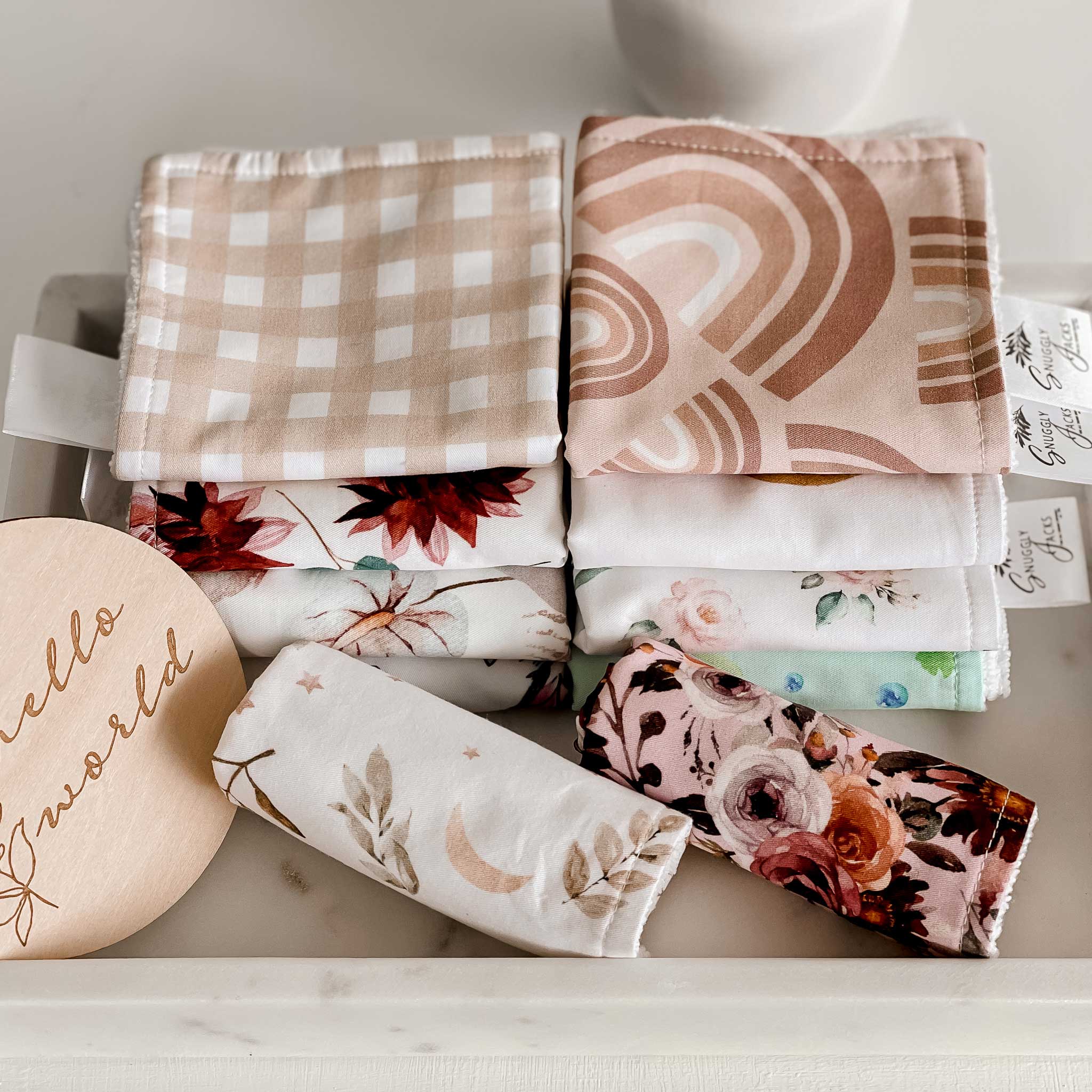2 piles and 2 individuale rolled wash cloths from snuggly jacks canada, floral prints, modern prints and traditional prints in a wide range of colours.