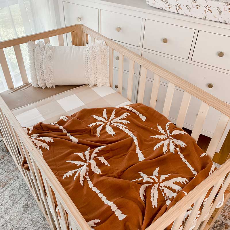 Baby Nursery with wooden crib and an Snuggly Jacks Havana Reversible Organic Knitted Blanket on the crib mattress