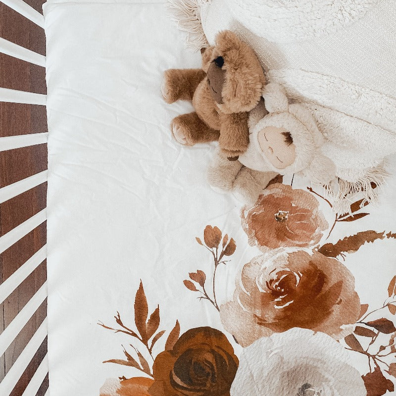 Over head shot of two plush toys living large in a crib set using snuggly jacks cotton nursery products