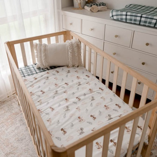 Pine crib in a modern nursery made up using a cotton filled crib quilt with dragon prints.