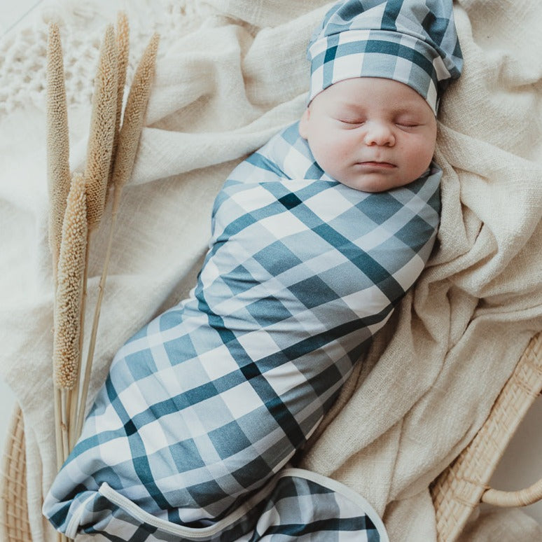 Adorable baby all wrapped up in a blue plaid swaddle wrap
