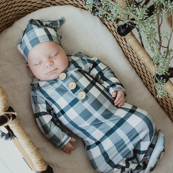 An adorable Baby all snug in a cyprus blue plaid knotted gown 