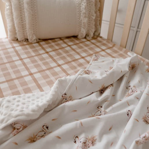 Pine crib made with a 100% cotton sheet fitted sheet and a white swan printed dimple dot minky