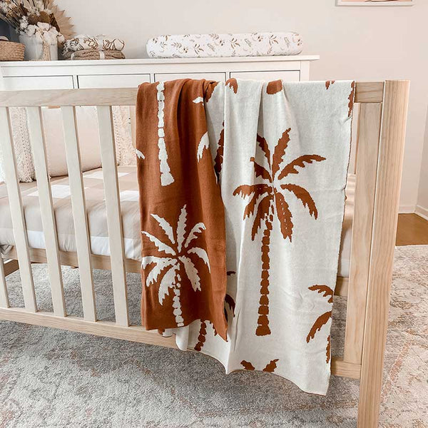 Baby Nursery with wooden crib and an Snuggly Jacks Havana Reversible Organic Knitted Blanket draped over the side of the crib